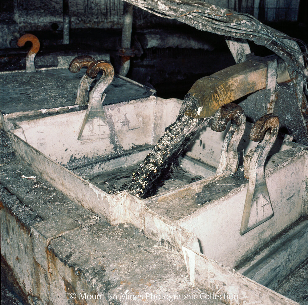 Pouring molten lead into block of molds, Mount Isa Mines, January 1987