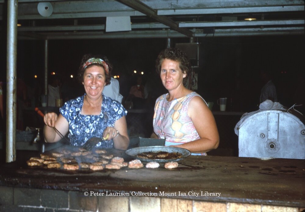Mrs Freeman and friend cooking hamburgers, Mount Isa Exhibition, Spear Creek, May 1963