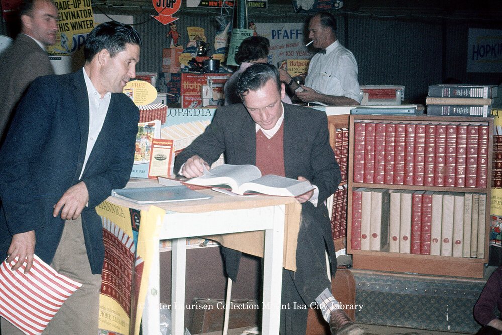 Man reading encyclopedia, Mount Isa Industrial Fair, Spear Creek, June 1962