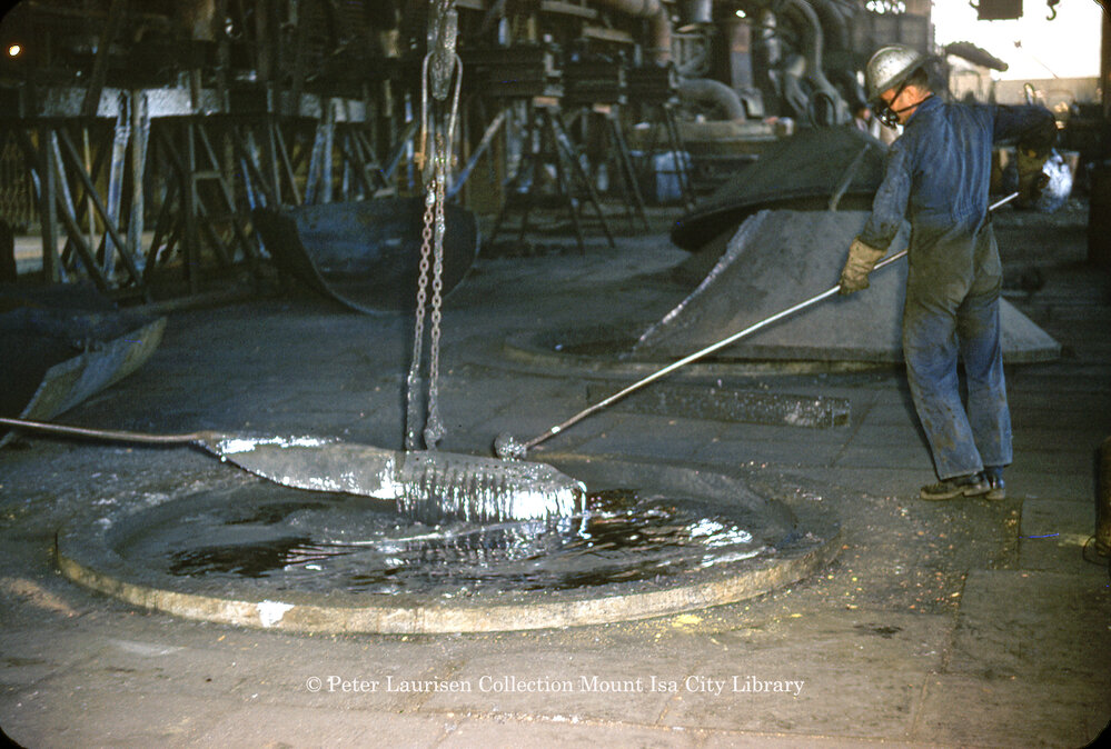 Stirring molten lead in drossing kettle at Lead Smelter, Mount Isa Mines, July 1956