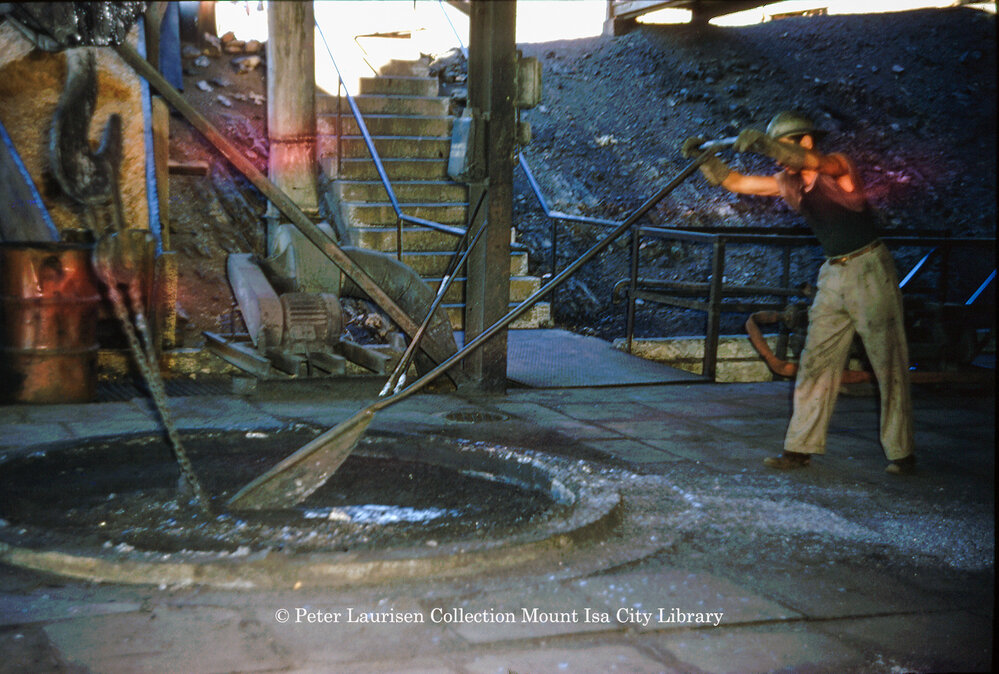 Stirring molten lead in drossing kettle at Lead Smelter, Mount Isa Mines, July 1956