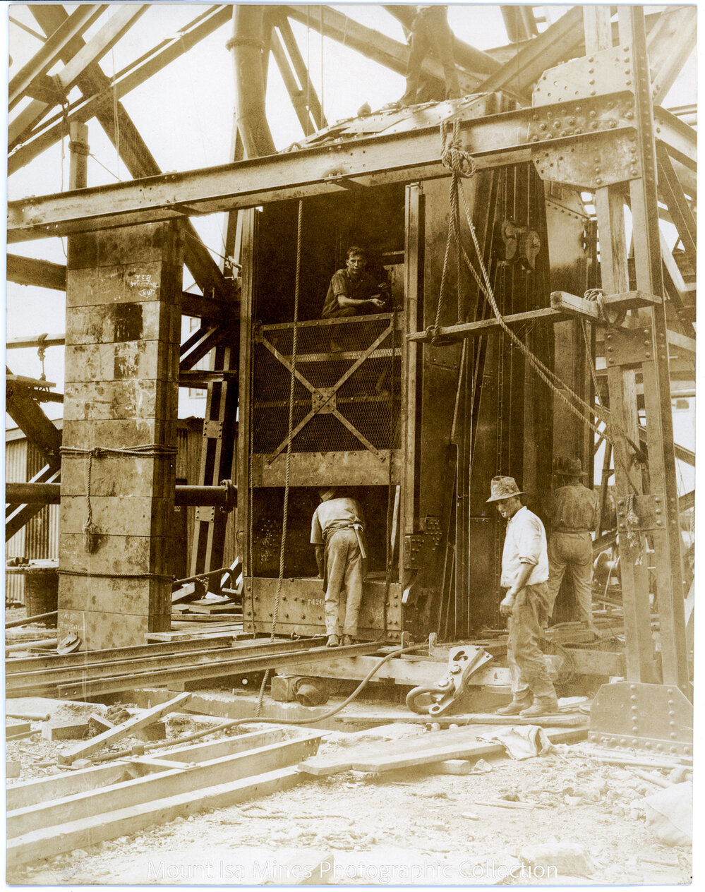 Man and Supply Man Cage and counterweights under construction, Mount Isa Mines, April 1931