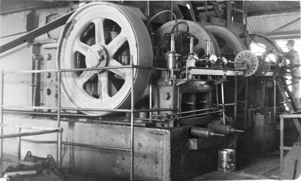 Jaw crusher with Morrie Cunningham greasing in the Mill, Mount Isa Mines, c.1948 