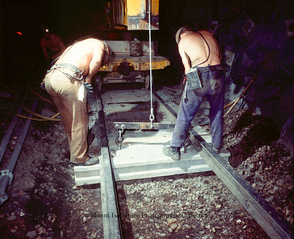 Workers laying concrete sleepers for underground haulage railway, Mount Isa Mines, March 1975