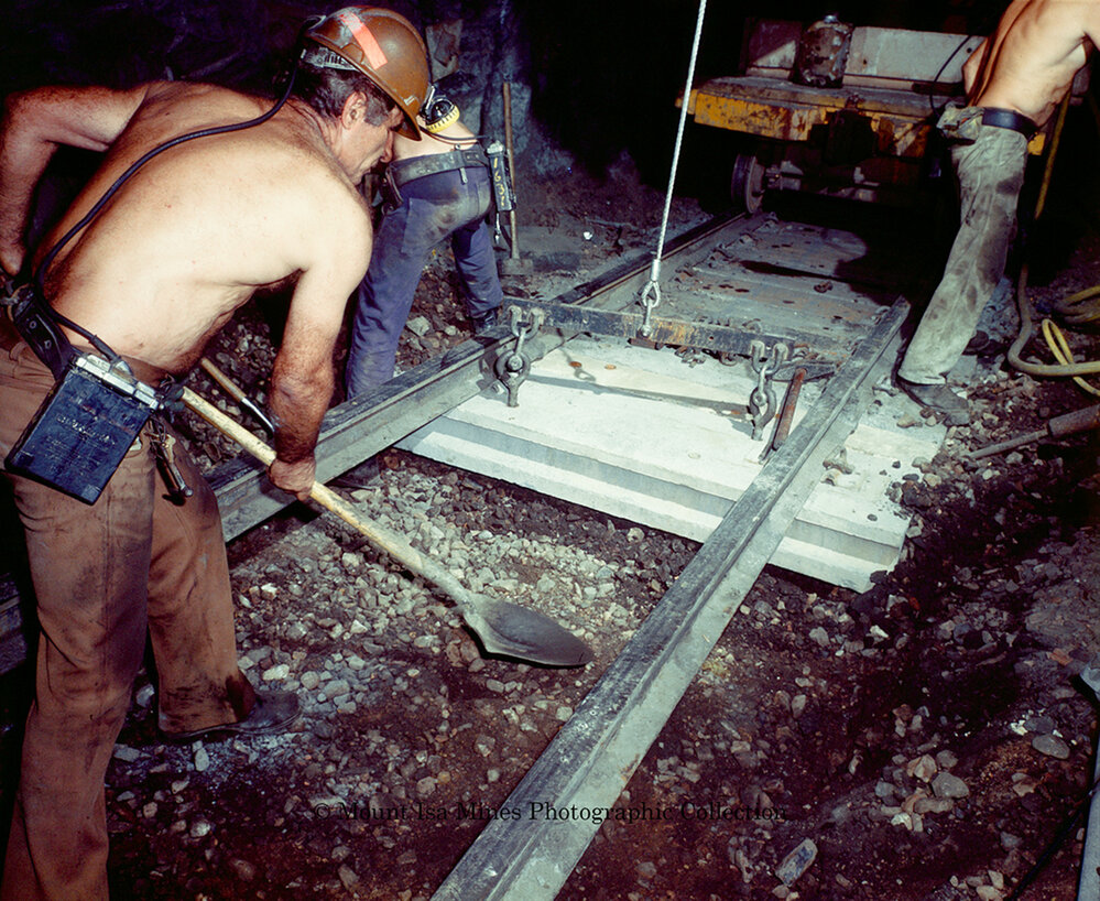 Workers laying concrete sleepers for underground haulage railway, Mount Isa Mines, March 1975