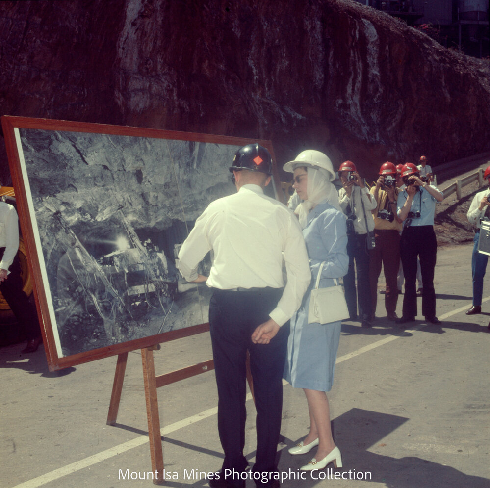 Queen Elizabeth II views photograph of underground drilling, Mount Isa Mines, April 1970