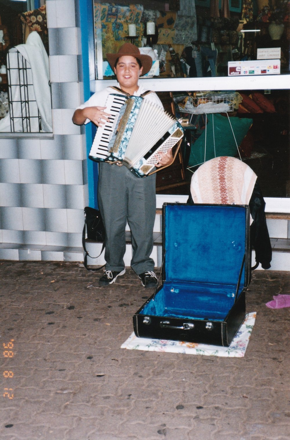 Busker playing accordion outside of store, c.1998