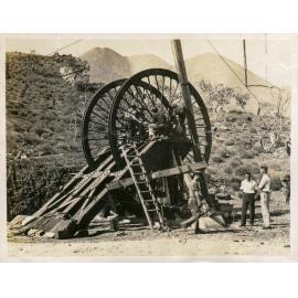 Workers installing sheave wheel over boreholes at No 2 ore shaft, Mount Isa Mines, c.1937