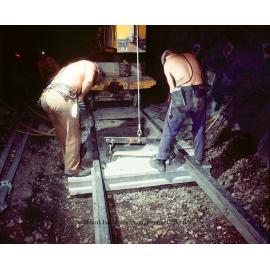 Workers laying concrete sleepers for underground haulage railway, Mount Isa Mines, March 1975