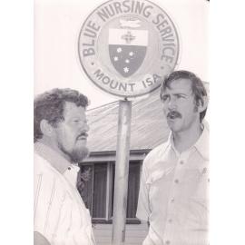 Two men standing outside the Blue Nursing Service headquarters