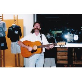 Mustached busker outside shop