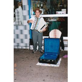 Busker playing accordion outside of store, c.1998