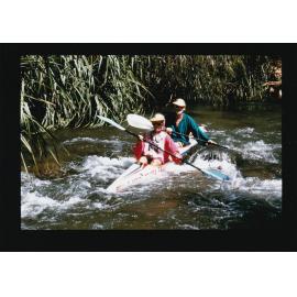 Couple kayaking in creek