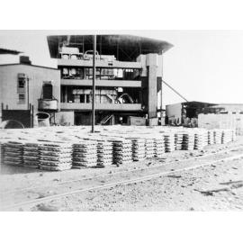 Stacked lead bars waiting for railway transport to Townsville, Mount Isa Mines, April 1964