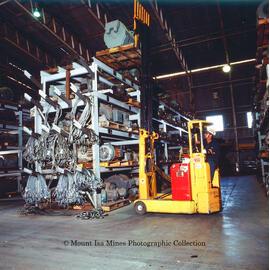 Forklift stacking an electric motor in No 2 Warehouse, Mount Isa Mines