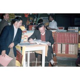 Man reading encyclopedia, Mount Isa Industrial Fair, Spear Creek, June 1962