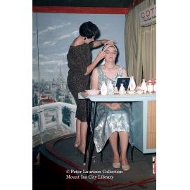 Woman getting make up, Mount Isa Industrial Fair, Spear Creek, June 1962