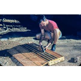 Worker placing drill core into diamond driller core box, Mount Isa Mines, c.1956