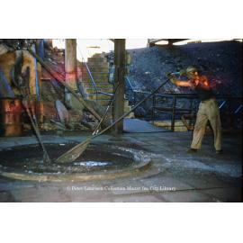 Stirring molten lead in drossing kettle at Lead Smelter, Mount Isa Mines, July 1956