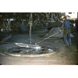 Stirring molten lead in drossing kettle at Lead Smelter, Mount Isa Mines, July 1956